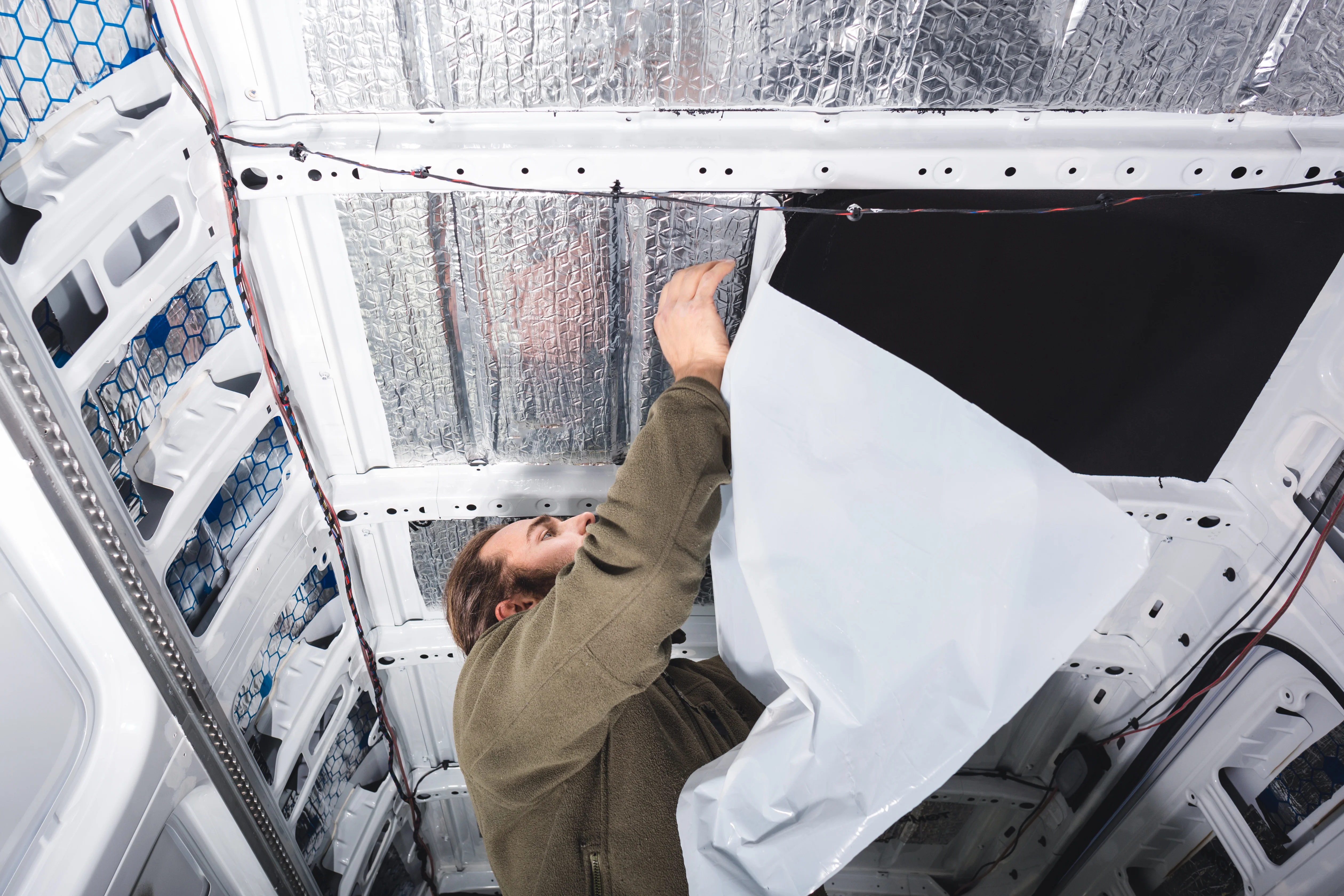 man insulating the ceiling of his van
