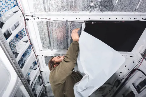 man insulating the ceiling of his van
