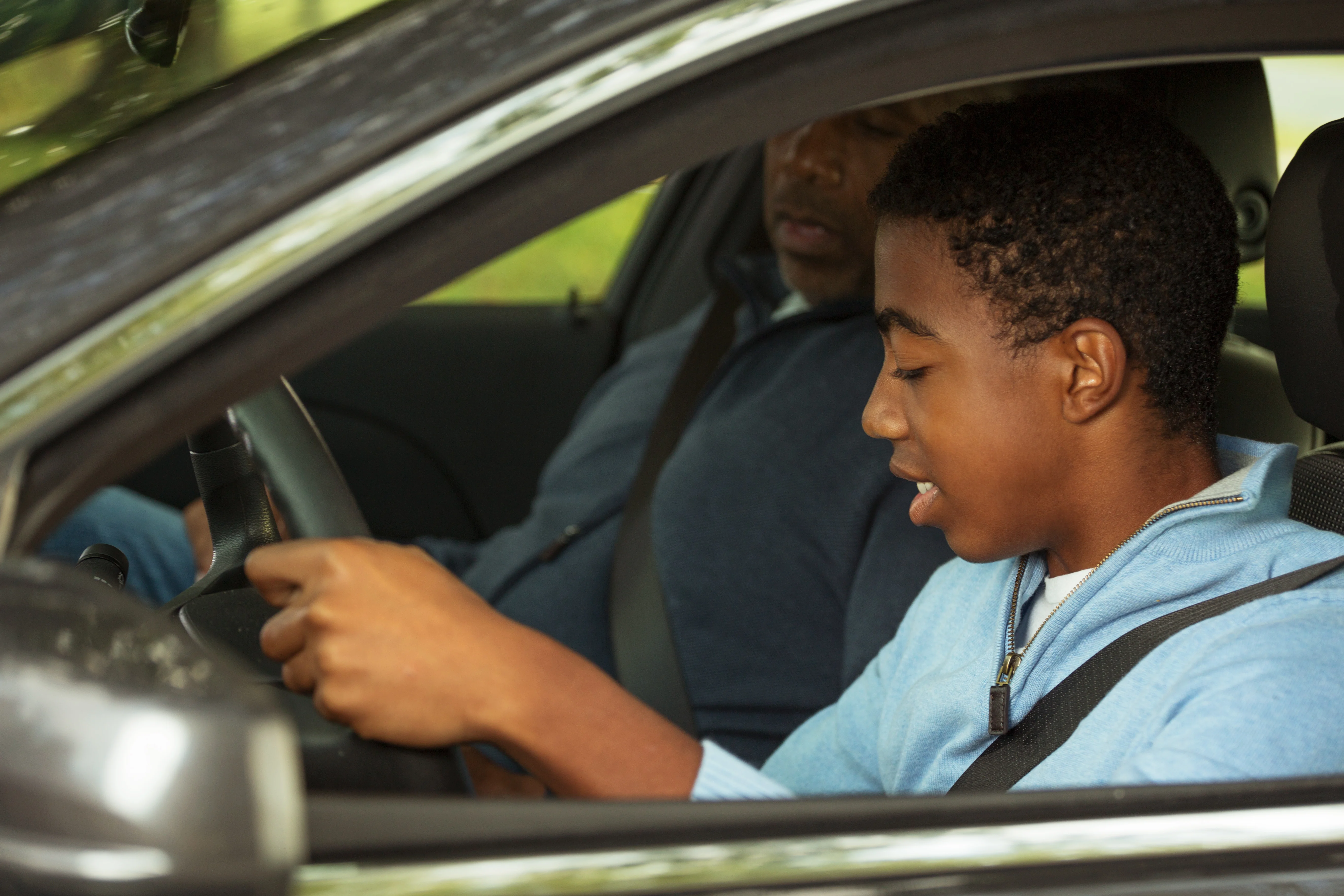 father teaching his son to drive