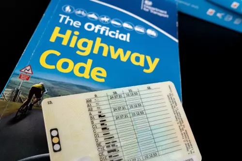 British Provisional Driving Licence on top of The Official Highway Code.